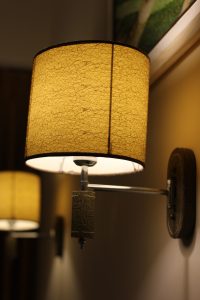 A close-up of a stylish wall lamp featuring a textured yellow lampshade with a cracked pattern