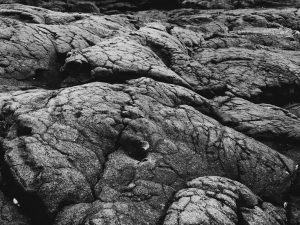 Black smooth and cracked ancient lava flow.
