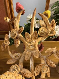 A decorative display featuring intricately carved branches and flowers made from a light-colored material.